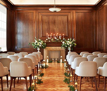Bromley Old Town Hall Ceremony Room with floor to ceiling wood panels and candle lit entrance.
