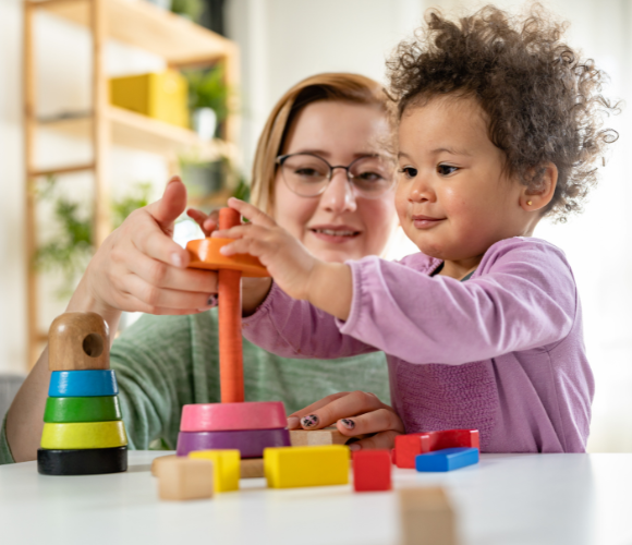 Image shows a women and a child stacking coloured rings.