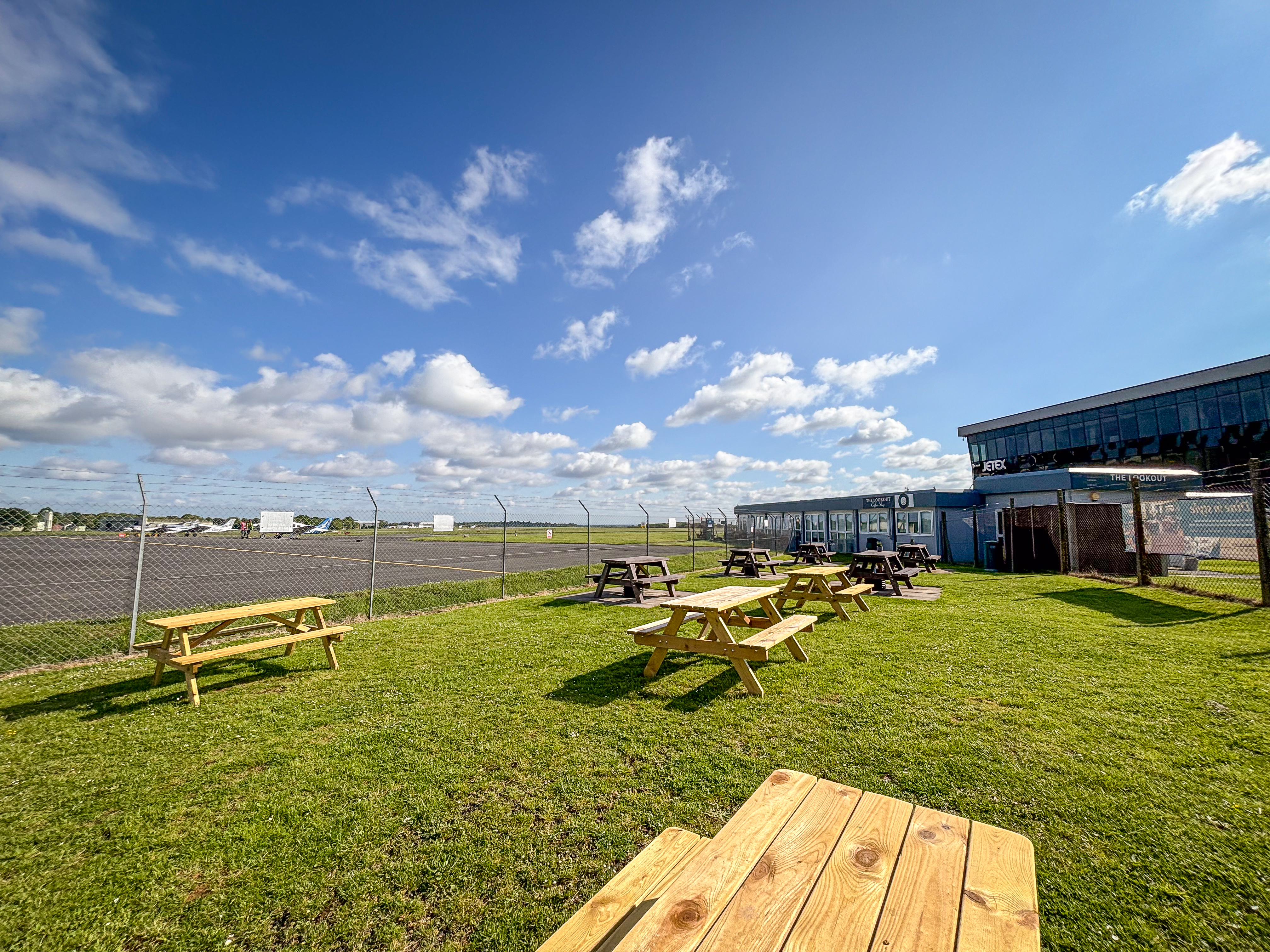 Image shows picnic benches on grass at the Look-out cafe Biggin Hill.