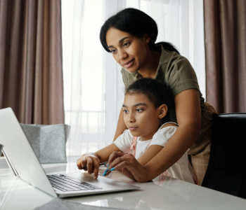 Image of an adult and child looking at a computer.