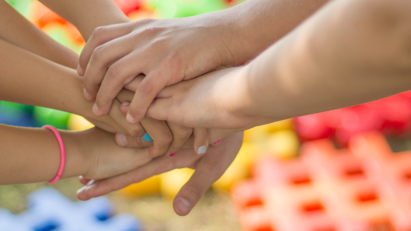 Photos of multiple pairs of hands stacked on top of each other.